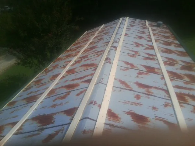Rusted metal roof panels with new wood purlins before replacement — Storm Damage Roof Repair in Gilberts by Roofing Brothers