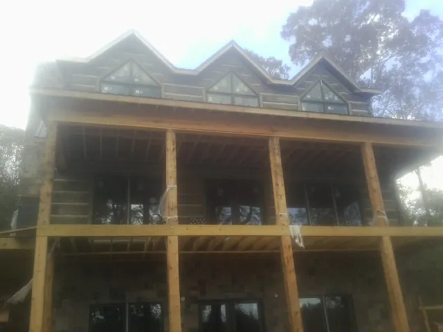 Dormers and porch framing on a large log home under construction — Roof Coating work by our crew in Gilberts