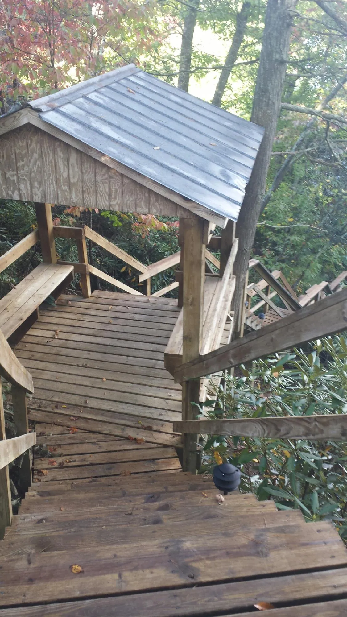 Metal roofed shelter over wooden steps on a wooded walkway — Skylight Repair & Installation work by our crew in Gilberts