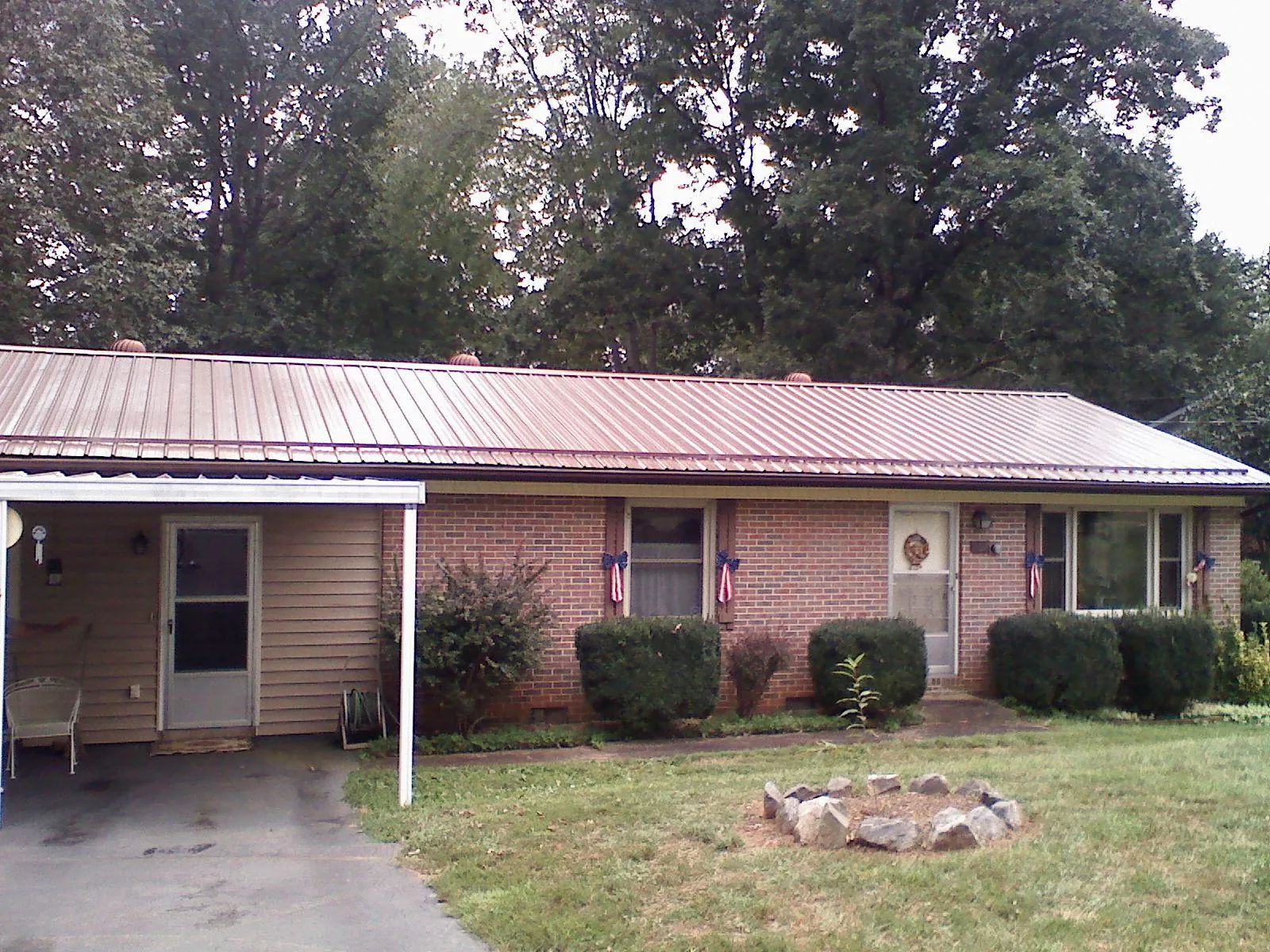 Bronze metal roof and carport on a brick ranch home — Roof Repair work by our crew in Gilberts